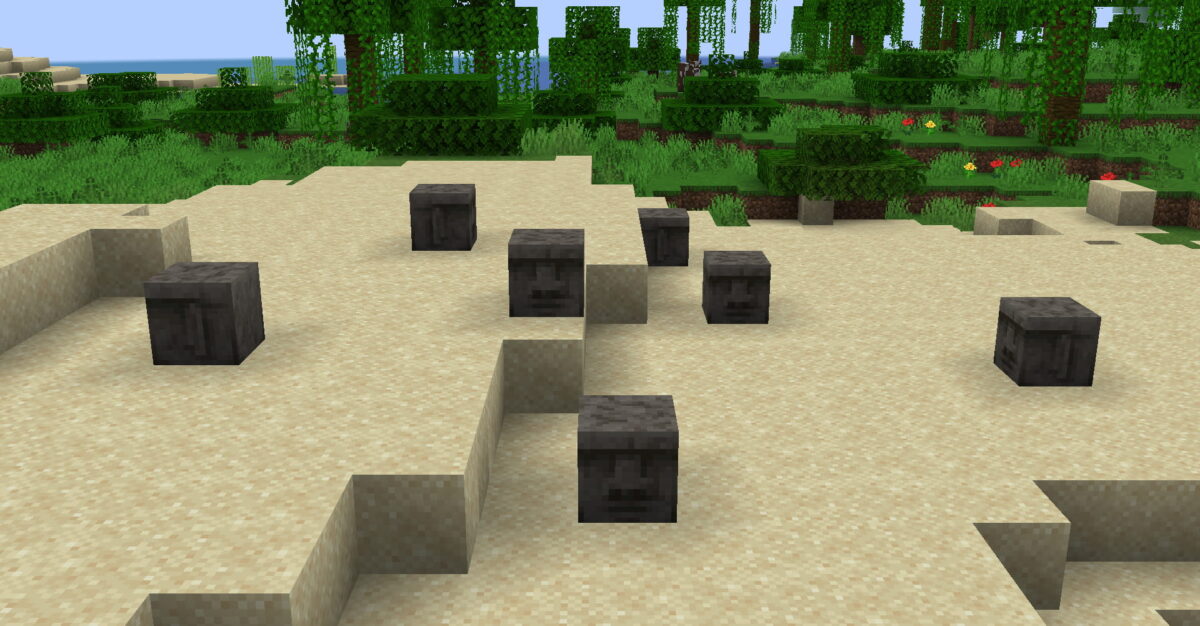 Têtes Moyai dispersées sur une plage Minecraft dans le mod Moyai