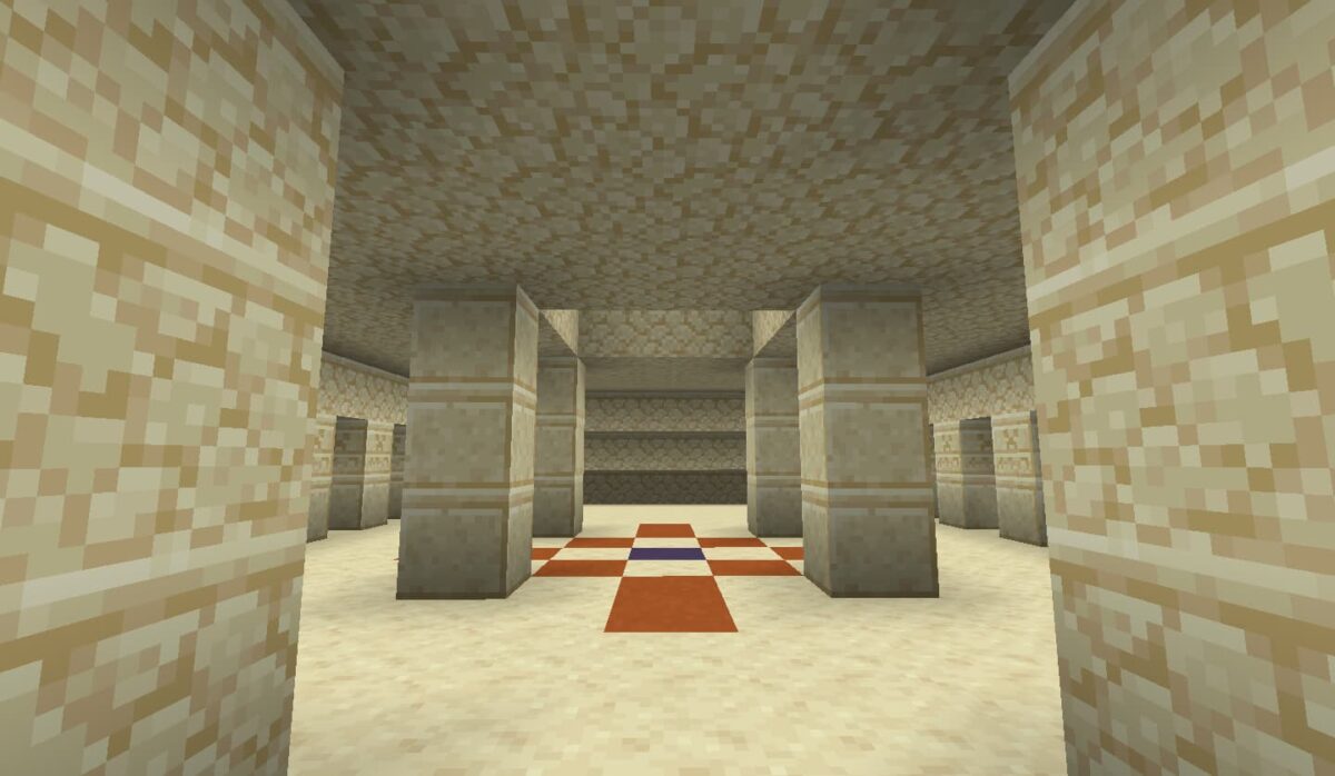 Vue intérieure de la pièce centrale d'une pyramide du désert dans Minecraft avec un motif en terracotta bleue et orange.