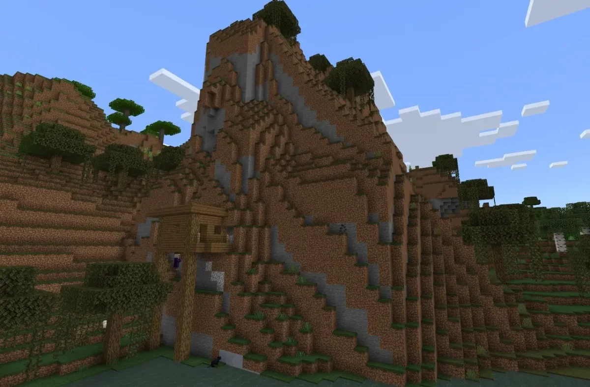Cabane de sorcière Minecraft construite contre une falaise avec piliers très hauts