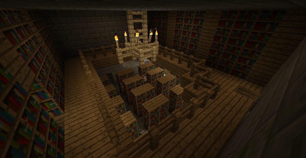 Intérieur d’une bibliothèque de fort dans Minecraft, avec un étage, des livres et un éclairage par torches.