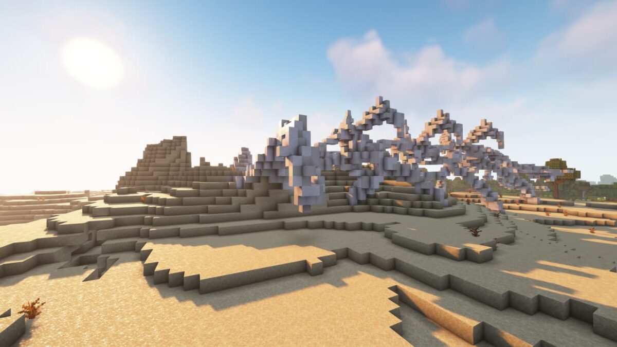 Squelette géant fossile partiellement enfoui dans le sable, structure rare dans le mod When Dungeons Arise pour Minecraft.