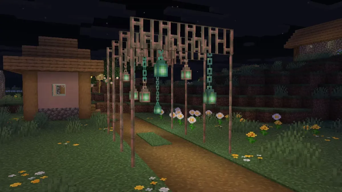 Entrée d’un village décorée avec des barreaux et des lanternes en cuivre dans Minecraft 1.21.9