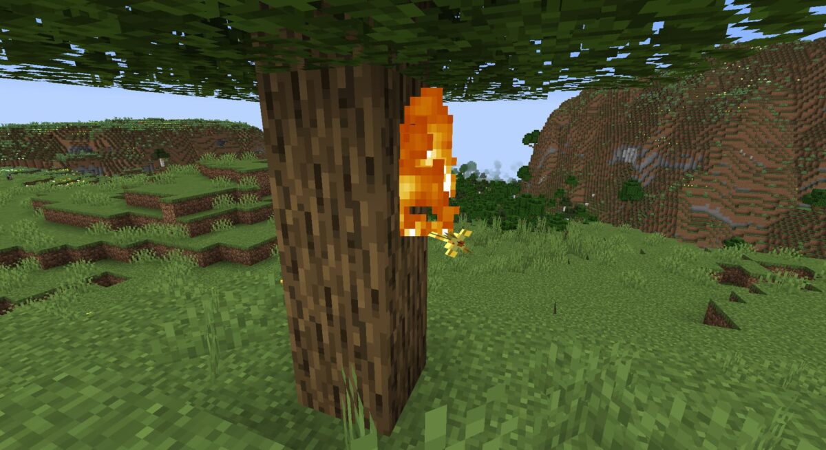Flèche spectrale enflammée plantée dans un tronc d’arbre dans Minecraft.