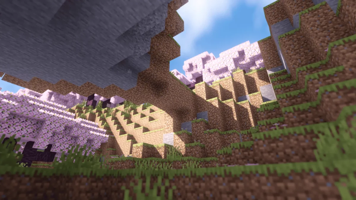 Paysage Minecraft avec une colline éclairée par le soleil et une forêt de cerisiers rosés, rendu avec le shader LITE shaders MakeUp edit.