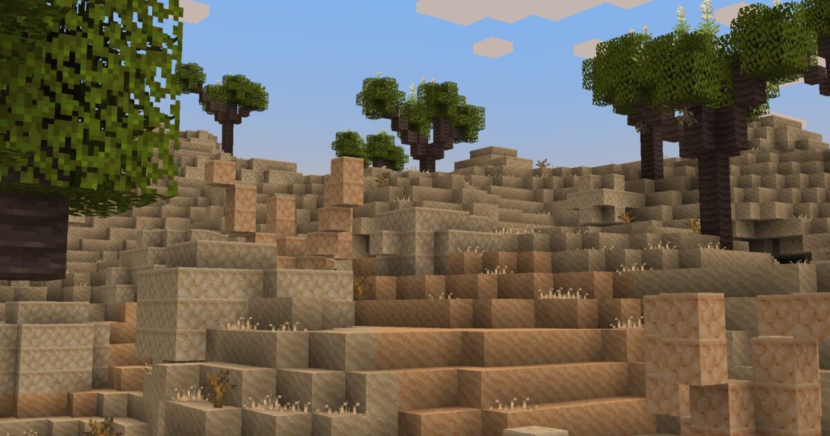 mod Minecraft Atmospheric illustrant un relief de dunes rocheuses parsemées d’arbres clairsemés