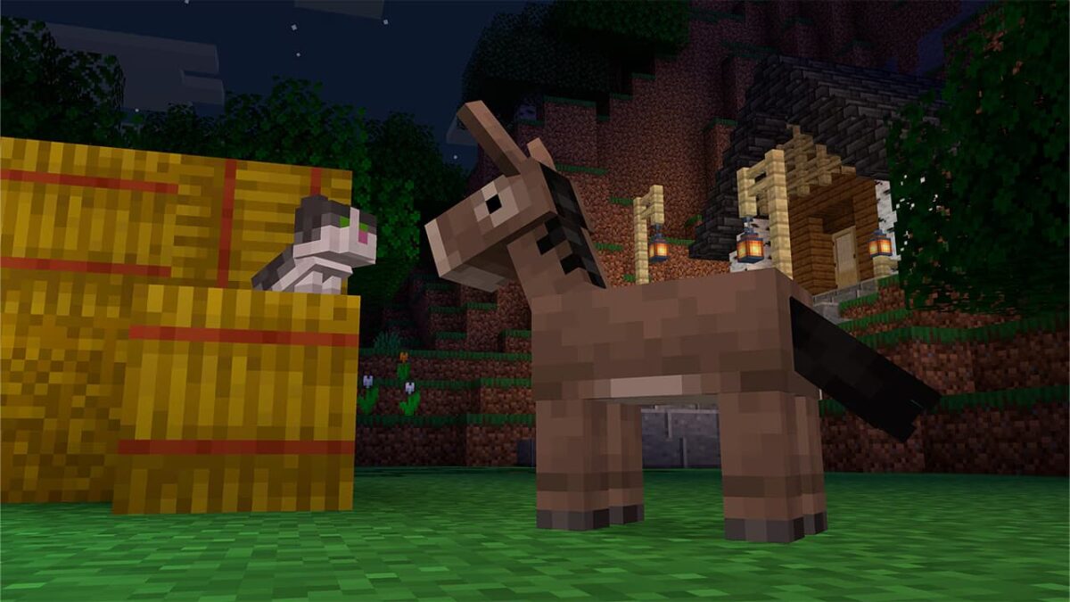 Bébé âne Minecraft avec son nouveau modèle juvénile près de bottes de foin devant une maison éclairée