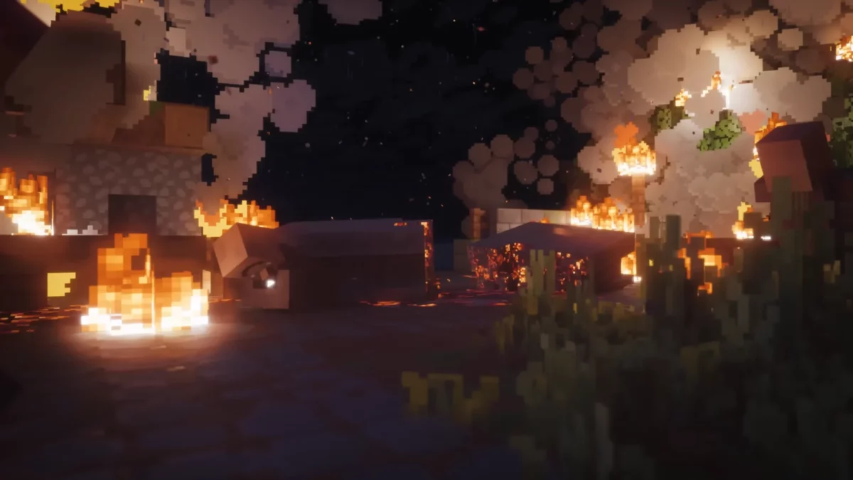 Capture du trailer de Minecraft Dungeons II montrant un village en feu dans la nuit, avec des bâtiments détruits, de la fumée et des flammes