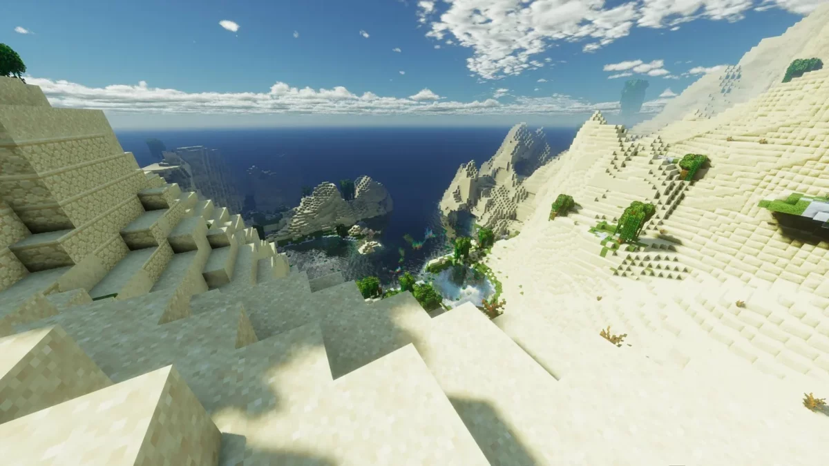 shader Minecraft Derivative Shader vue ensoleillee de dunes de sable surplombant un ocean bleu sous un ciel degage