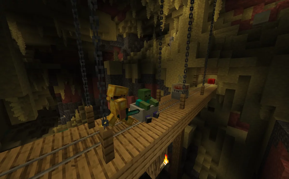 Joueur poussant un zombie vers un cube de soufre chargé de TNT sur un pont de mine dans Minecraft