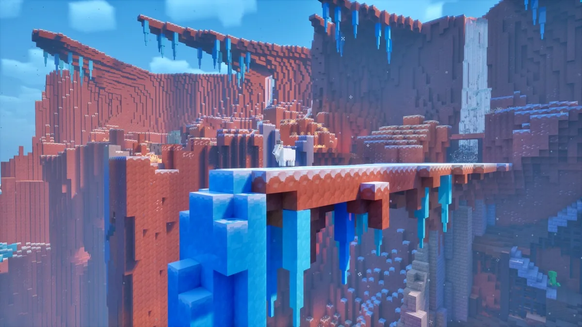 Minecraft Dungeons II un canyon gelé aux falaises rouges avec des structures de pierre et des stalactites de glace