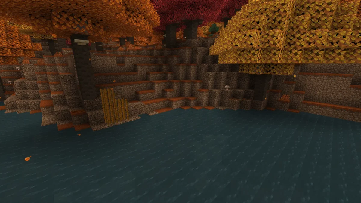 Eau bleu très sombre au pied d'une falaise de terre stérile dans une forêt tachetée de Minecraft, sous une canopée de peupliers rouges et orange