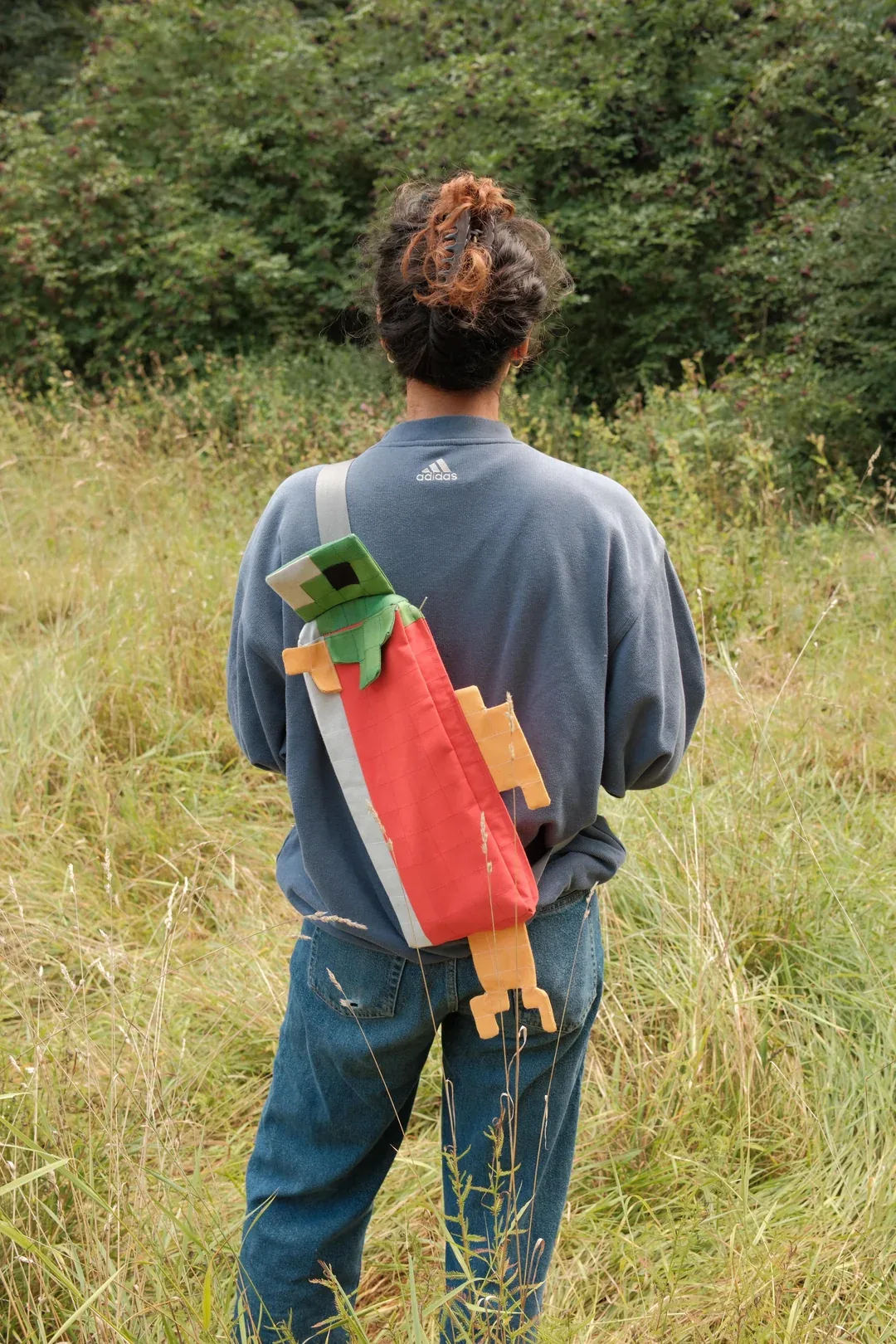Sac saumon Minecraft porté de dos avec sa tête verte et ses nageoires orange