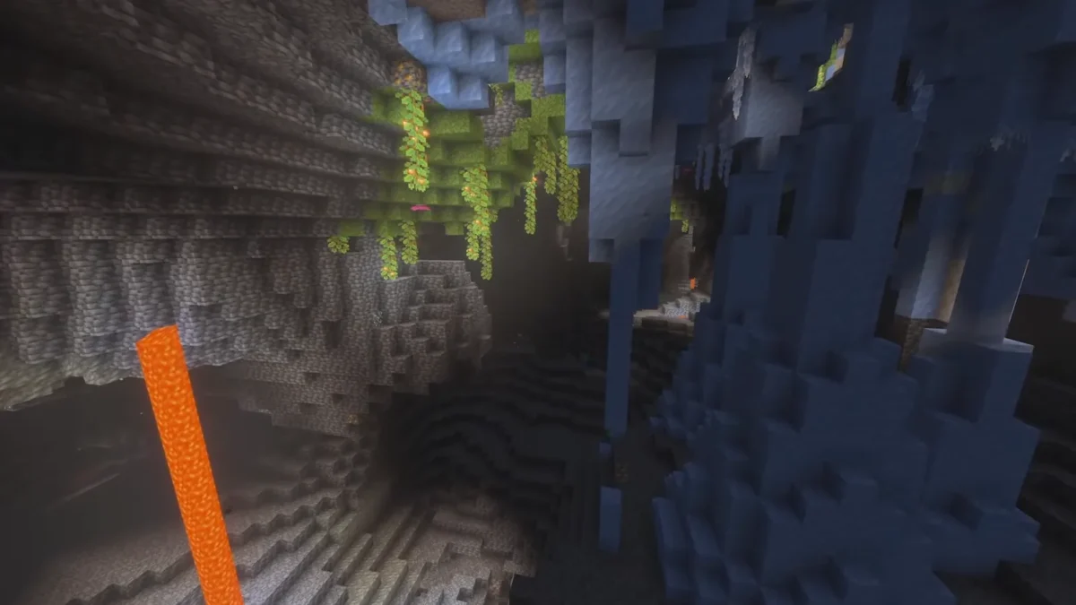 Une grande cavité montre des parois gelées près de végétation et d’une cascade de lave dans Minecraft