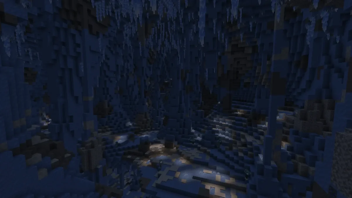 Caverne de glace sombre dans Minecraft, avec des stalactites suspendues et de petits cristaux lumineux répartis au sol