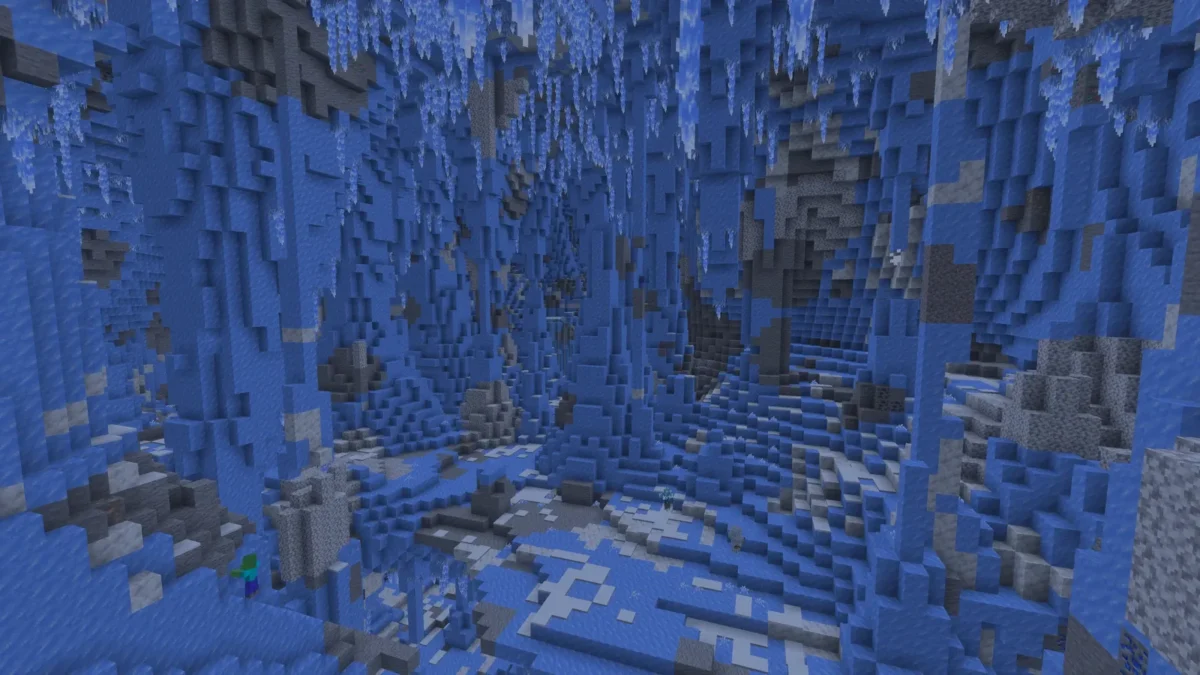 Vue éclairée d’une caverne de glace dans Minecraft, avec des colonnes de glace, des stalactites au plafond et des cristaux au sol